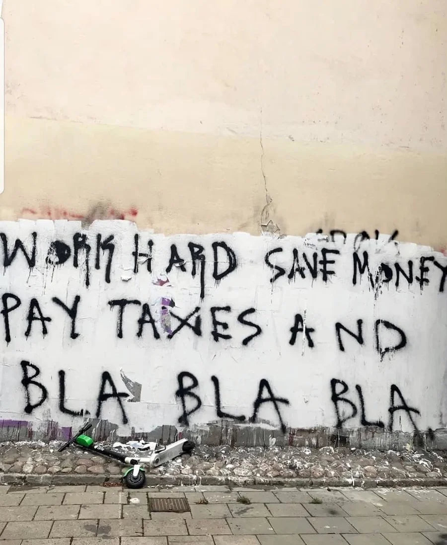 Street wall with black handwritten lettering above cobblestones