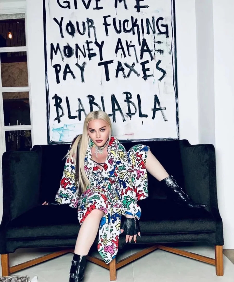 A seated person in front of a large handwritten BLA BLA BLA artwork
