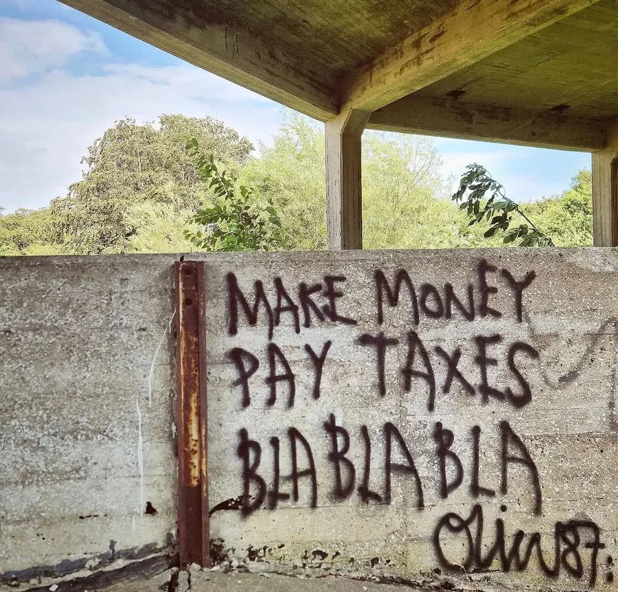 BLA BLA BLA and handwritten words on a concrete wall beneath a roof
