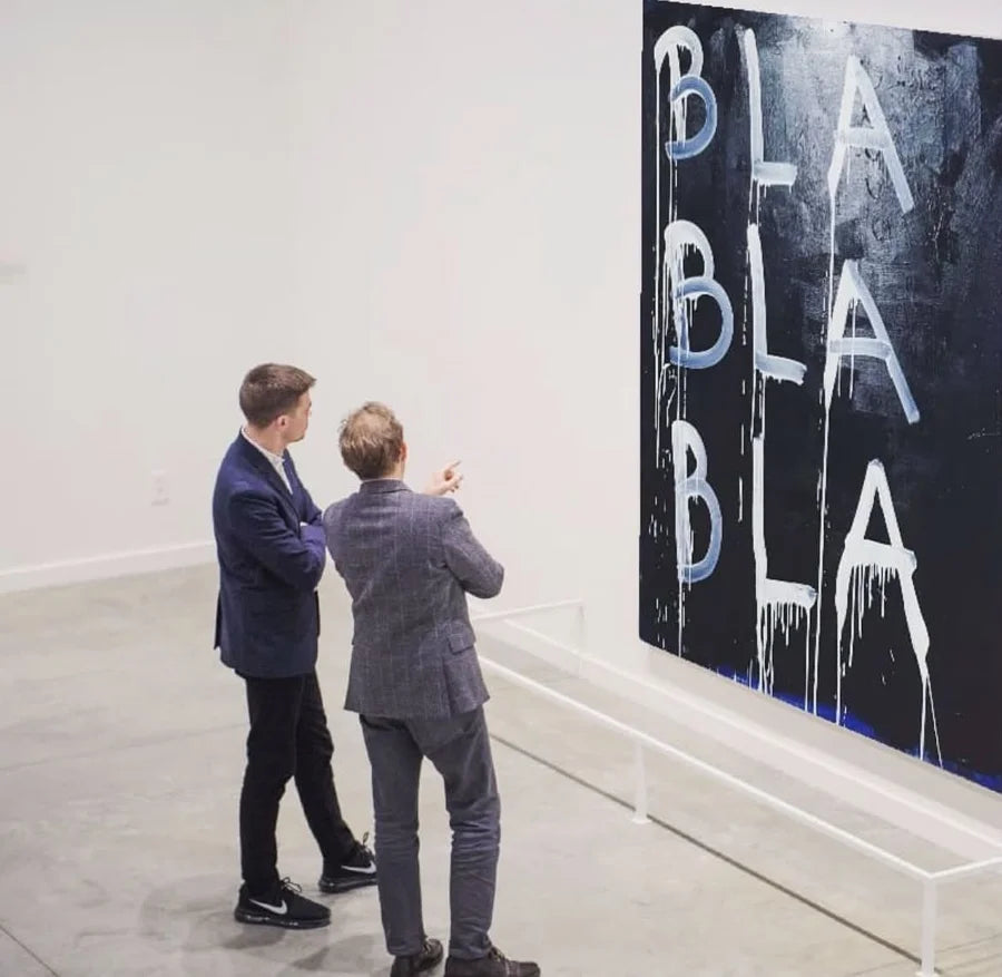 Two visitors looking at a large dark BLA BLA BLA painting