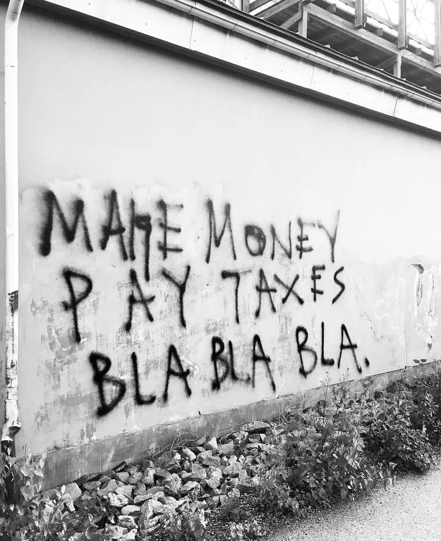 Black and white photograph of sprayed words on a white exterior wall